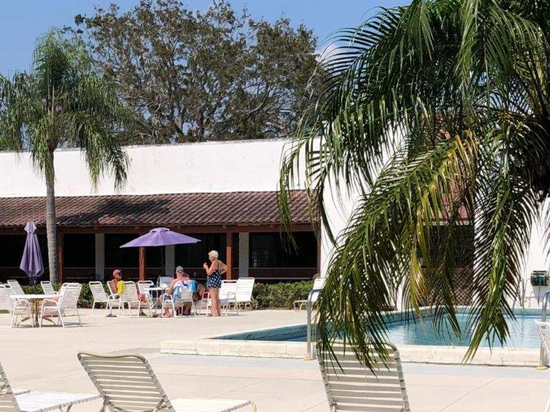 Spanish Lakes Golf Village's pool area and large clubhouse behind it.