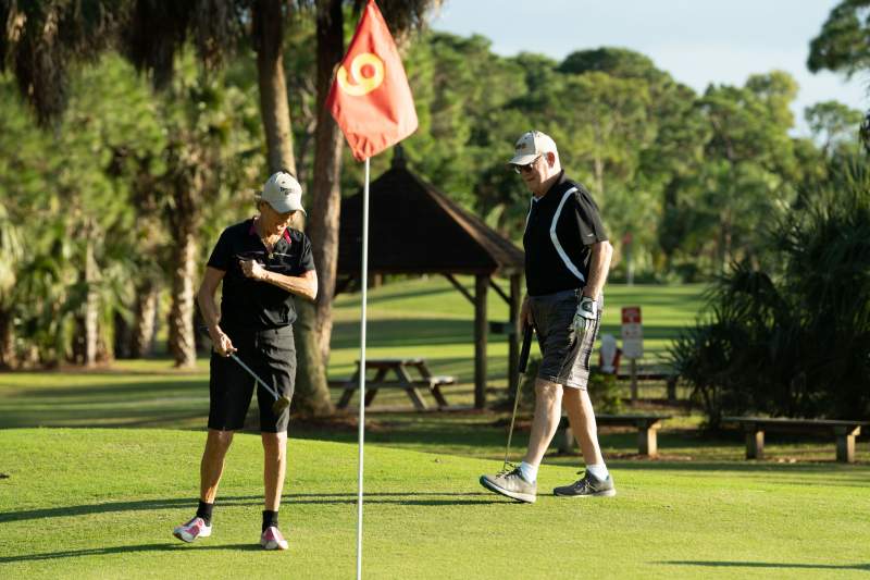 Two people playing golf. 